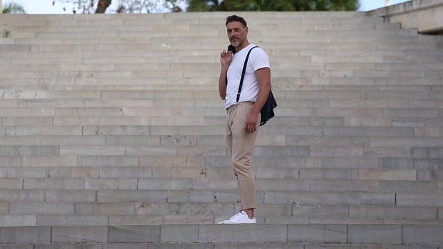 Hombre de mediana edad con vestido con ropa sport con chaqueta y tirante