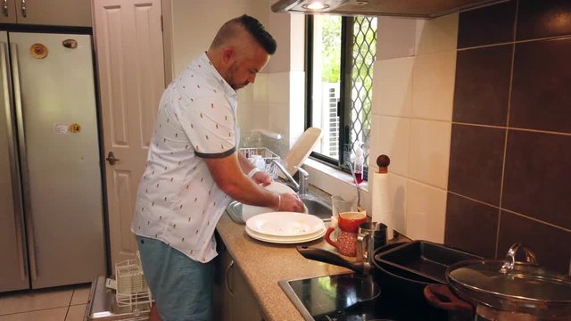 man washing the dishes in the sink, washing plates, rinsing plates and drying plates,