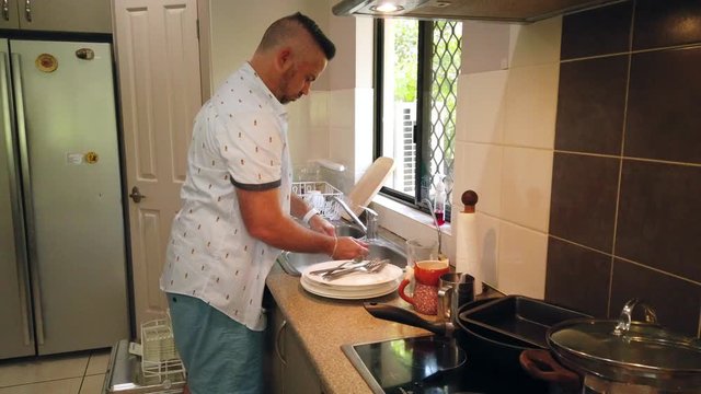 Great husband washing the dishes, specifically the potato masher in slow motion