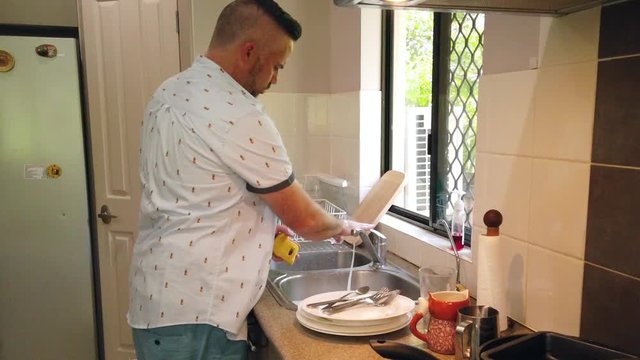 great husband washing the dishes,  specifically washing a coffee mug, in slo motion