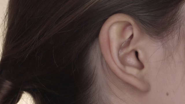 Close up on female ear. Hearing sense concept.
