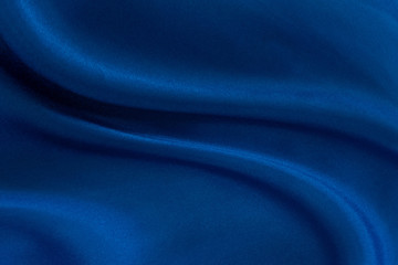 Luxury deep blue fabric background.Smooth wavy fold pattern.Elegant curve.Silk velvet material texture.Using for backdrop or wallpaper.Dark tone color.