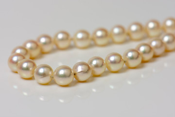 Close up of sphere natural pearl necklace on white background. Selective focus.