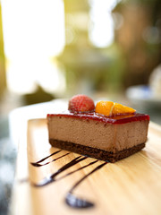 Delicious dessert. Strawberry and orange fruit cake placed on a wooden tray. Close up shot.