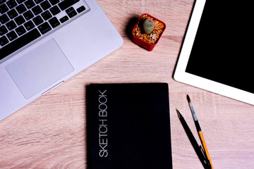 book cactus tablet pencil paintbrush on wood the table