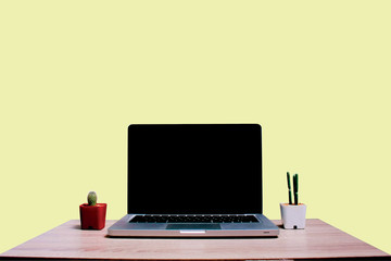 laptop and cup of coffee on wooden table on isolate pastel yeloow background
