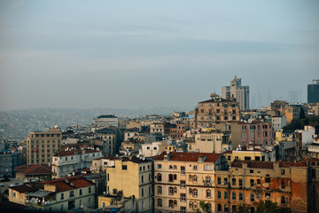 Top view on the roofs of Istanbul Turkey houses against the backdrop of the Bosphorus with ferry cargo cranes at sunset.