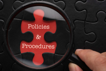 Magnifying glass focus on puzzle written Policies and Procedures. Simple business concept, - obrazy, fototapety, plakaty