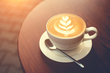 Cup of cappuccino on wooden table.