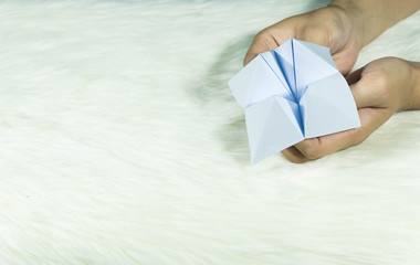The man's hand is holding a paper that predicts the fate known as Paper Fortune Tellers. To predict the future, work, love, fate, sometimes used as a fun game to play. There is space for copy space.