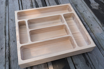Wooden tray, cutlery organizer on a gray background