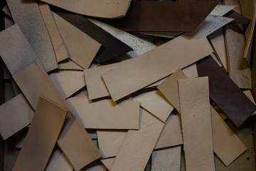 Pieces of genuine leather in the workshop. Sliced ​​vegetable tanned leather.
