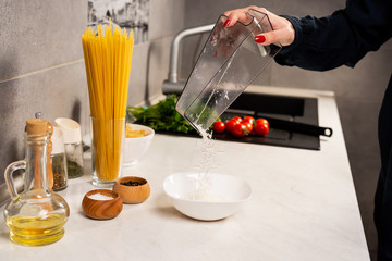 Cooking italian pasta in a pot in the kitchen, Chef preparing food, meal. Woman cook pulls out of the pan ready-made pasta fusilli