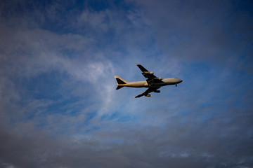 Airplane preparing for landing amongst clouds at sunset