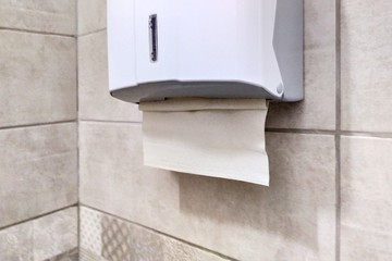 Paper towel holder in the bathroom. Dispenser with paper towels. Drawer with paper napkins for...
