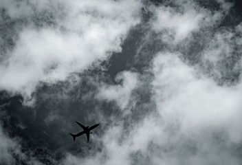 Fototapeta na wymiar Airplane flying on dark sky and white clouds. Commercial airline with dream destinations concept. Aviation business crisis concept. Failed journey vacation flight. Air transportation. Sad travel.