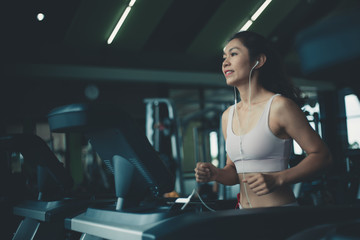Fototapeta na wymiar Asian young fitness woman on the treadmill in the gym.