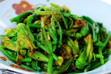 Plate of pumpkin flower buds fried with cooking oil for vegetarian meal
