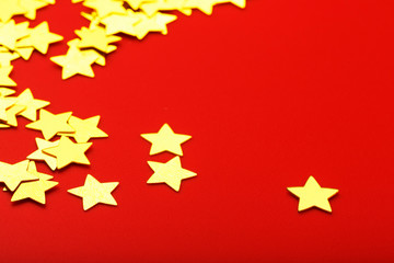 A scattering of Gold stars on a red background. Greeting cards, headlines and website concept.
