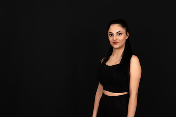 Fototapeta premium Strong looking girl doing sports on a black background