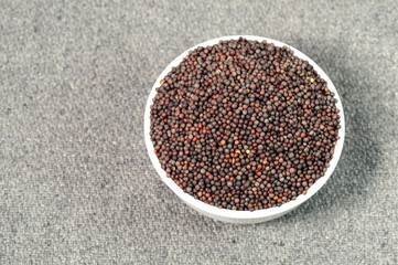 Brown Mustard Seeds in bowl on sackcloth