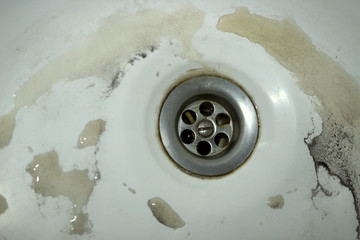 the drain is clogged, rusty dirty water flows in bathroom