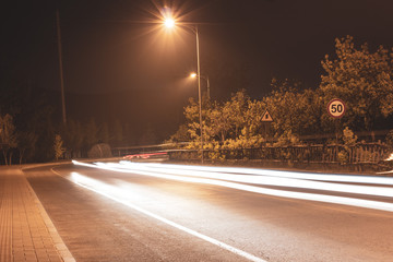 Car light tracks under tree bypass lights at night