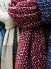 Wool scarves hang in the shop window. Colorful scarves tied in a knot