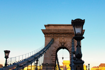 Picturesque view of Chain Bridge silhouette during autumn sunset. Beautiful ancient lantern. Romantic and peaceful scene. Panoramic dramatic sunset sky. Budapest, Hungary