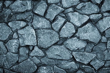 Gray stone wall background. Mosaic of bricks in retro style, modern. Dark rock texture, brick wall pattern. Grey grunge surface.
