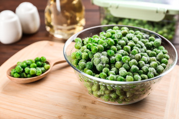 Frozen green peas on wooden table, closeup. Vegetable preservation