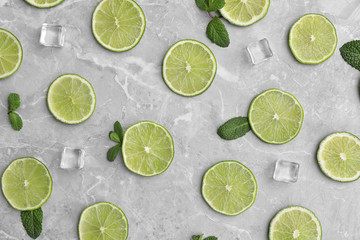 Flat lay composition with slices of fresh juicy limes on marble table