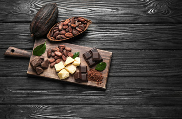 Flat lay composition with organic cocoa butter on black wooden table. Space for text