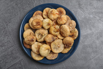 Tasty dried figs on grey table, top view