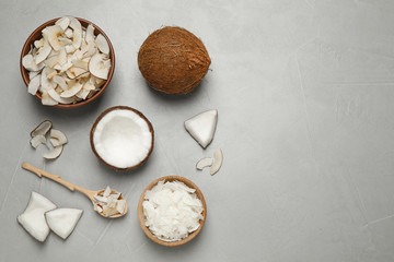 Flat lay composition with tasty coconut chips on grey table. Space for text
