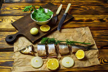 herring on a plate, salted fish with fruits on a wooden background, selective focus, warm filter