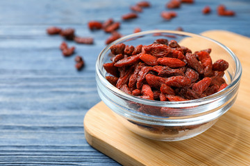 Dried goji berries on blue wooden table, closeup