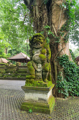 A stone statue in the sacred monkey forest. Ubud, Bali, Indonesia