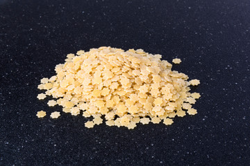 Handful of star shaped dried dehydrated pasta pieces