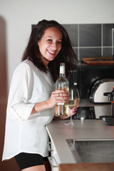 Jolie jeune femme brune dégustant un verre de vin