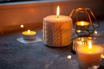 Candles on windowsill. Hygge concept, close-up