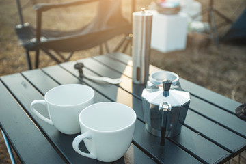 Ground coffee and moka pot coffee maker, Outdoor moka coffee set on picnic table and camping on the morning.