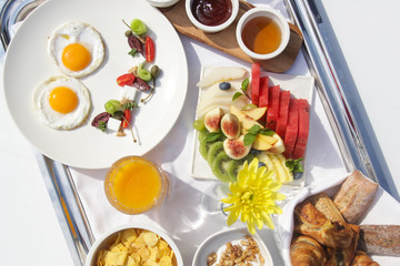 Sunny side up eggs, fresh squizeed orange juice, fruit salad and cereals, healthy organic breakfast option