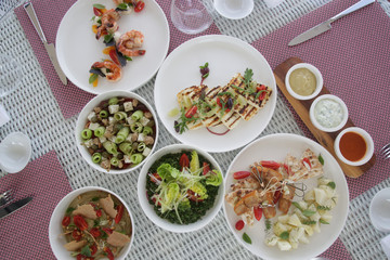 Various healthy fish and vegetables meals served on the table, healthy summer lunch	