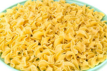 Pile of many yellow dehydrated uncooked egg noodles