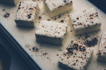 Paneer Dum Kali Mirch / Kalimirch, prepared in a white creamy gravy and black pepper powder sprinkled over it. served in a bowl. Selective focus