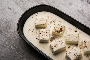 Paneer Dum Kali Mirch / Kalimirch, prepared in a white creamy gravy and black pepper powder sprinkled over it. served in a bowl. Selective focus