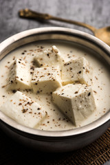 Paneer Dum Kali Mirch / Kalimirch, prepared in a white creamy gravy and black pepper powder sprinkled over it. served in a bowl. Selective focus
