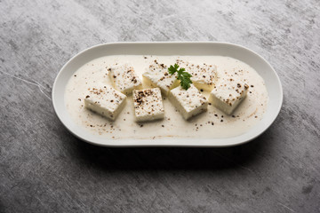 Paneer Dum Kali Mirch / Kalimirch, prepared in a white creamy gravy and black pepper powder sprinkled over it. served in a bowl. Selective focus