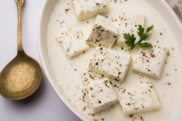 Paneer Dum Kali Mirch / Kalimirch, prepared in a white creamy gravy and black pepper powder sprinkled over it. served in a bowl. Selective focus